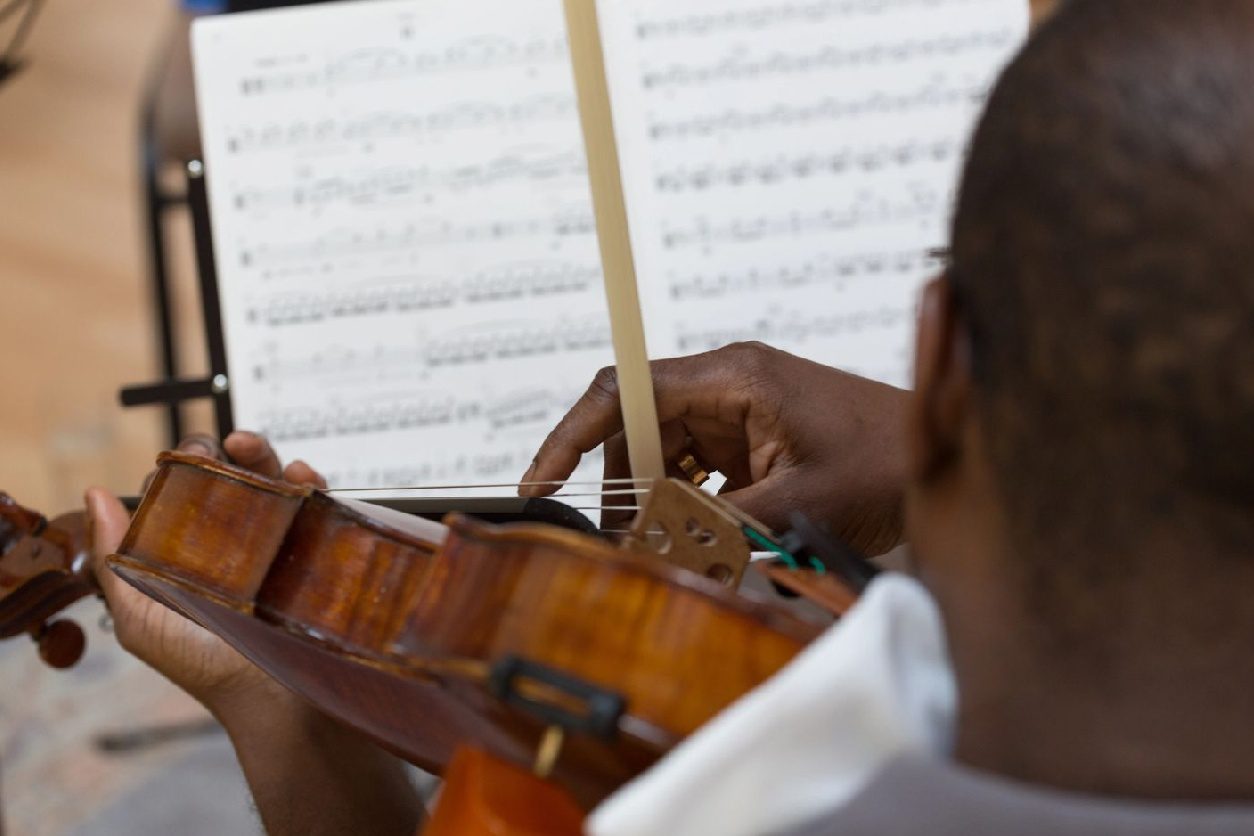 A person playing the violin with sheet music in front of them.